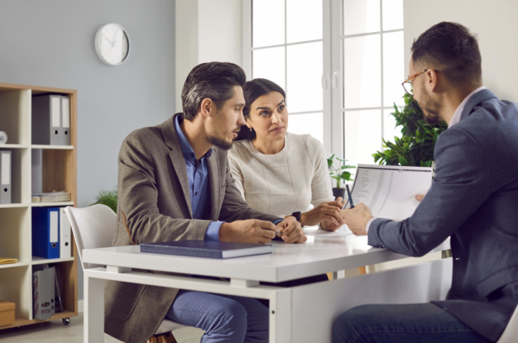 Two people talking about insurance with an advisor.